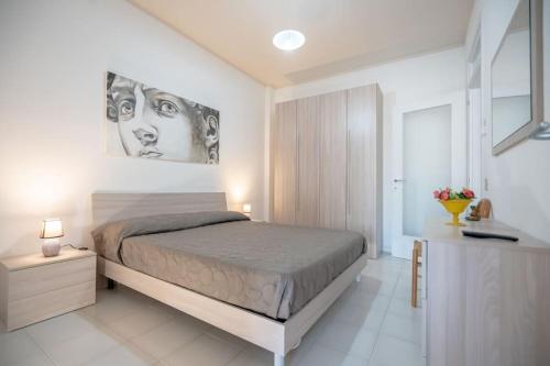 1 dormitorio con 1 cama y una pintura en la pared en Il Corallo, en Vasto