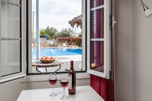 two glasses of wine sitting on a table next to a window at Aggeliki's Diamond in Agia Anna Naxos