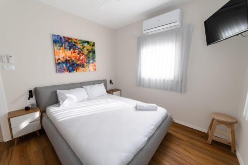 a bedroom with a white bed and a window at O&O Group - Amazing Seaview 3 BR Apartment in Bat Yam