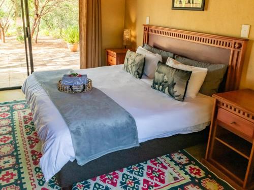 a bedroom with a large bed with a tray on it at Impala Cottage in Hoedspruit