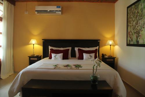 a bedroom with a large bed with red pillows at El Pueblito Iguazú in Puerto Iguazú