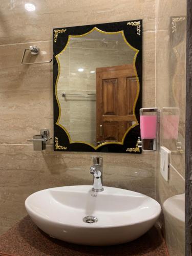 y baño con lavabo y espejo. en Khadee Homestay en Srinagar