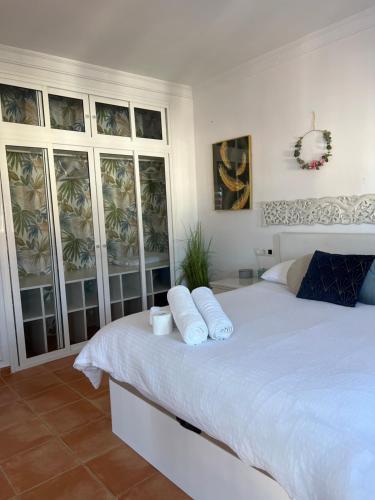 a bedroom with a white bed with towels on it at Circus-Goretti House in Mairena del Aljarafe