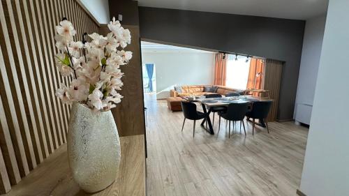 South Apartmani في فرانيي: غرفة معيشة مع مزهرية مع الزهور البيضاء فيها
