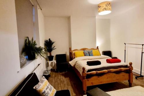 a bedroom with a bed and a potted plant at Cosy split-level 2 bed apartment in Leicester