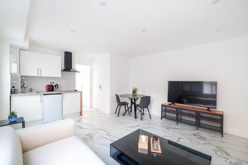 un salon avec un canapé blanc et une table dans l'établissement Spacious flat for 4 people #1, à Asnières-sur-Seine