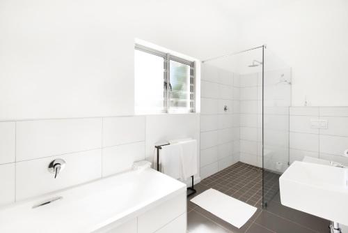 a white bathroom with a sink and a shower at Fransmanskraal Accommodation - Luxury Stellenbosch Farm Villa in Stellenbosch