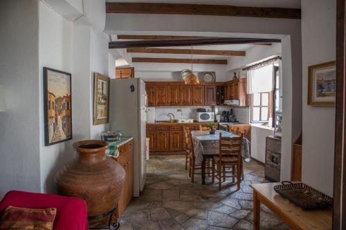 a kitchen with a table and a refrigerator at Maries Thasos Stone Villa in Mariaí