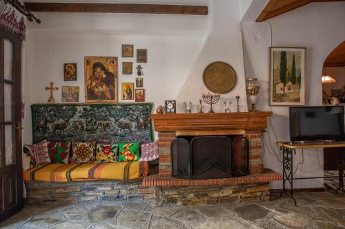 a living room with a fireplace and a tv at Maries Thasos Stone Villa in Mariaí