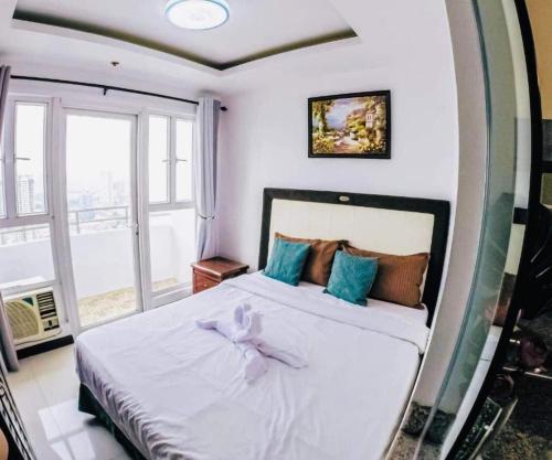 マニラにあるBirch Tower Malate Suitesのベッドルーム(弓を用いた白いベッド1台付)