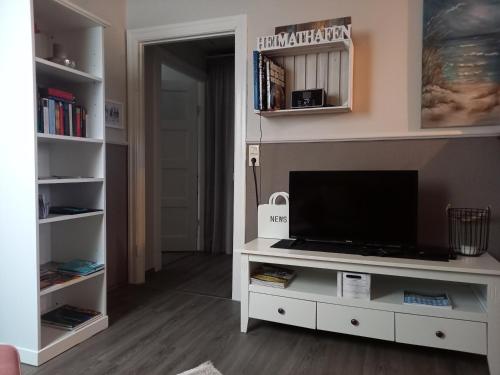 a living room with a tv on a white entertainment center at Ferien zwischen den Meeren in Jübek