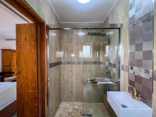 a bathroom with a shower with a sink and a tub at flagridge county lodge in Flagstaff