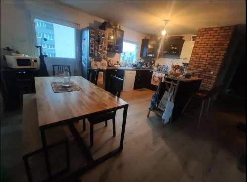 - une cuisine avec une table en bois dans une chambre dans l'établissement Chambre chez l'habitant en rooftop, à Ivry-sur-Seine