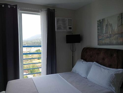 1 dormitorio con cama y ventana con vistas en Loop Spacious Studio Unit en Cagayán de Oro