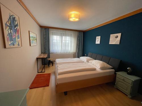 ein Schlafzimmer mit einem Bett und einer blauen Wand in der Unterkunft Landgasthof Zum Alten Weinstock in Rudersdorf