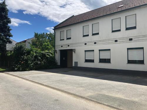 a white building with a garage and a driveway at Landgasthof Zum Alten Weinstock in Rudersdorf