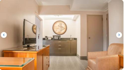a living room with a couch and a television at Empire Suites in Montréal