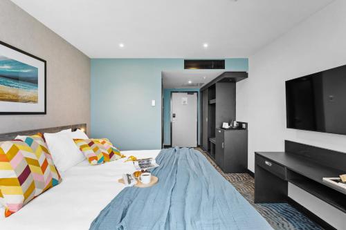 a hotel room with a bed and a flat screen tv at ibis Styles Paignton in Paignton