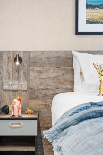 a bedroom with a bed and a table with a night stand at ibis Styles Paignton in Paignton