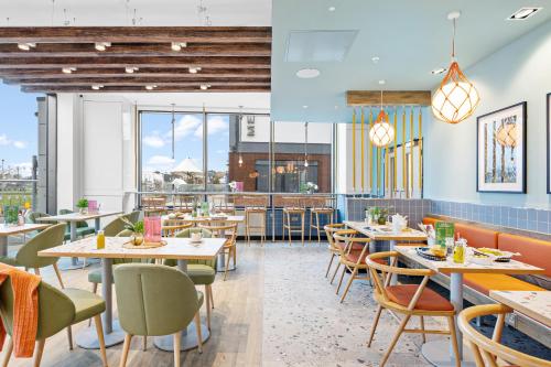 a restaurant with tables and chairs and windows at ibis Styles Paignton in Paignton
