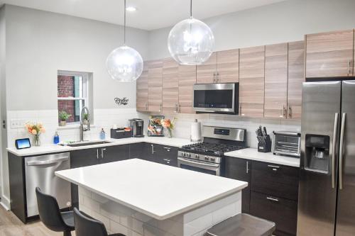 cocina con electrodomésticos de acero inoxidable y encimera blanca en Steel City Getaway w/City View, en Pittsburgh