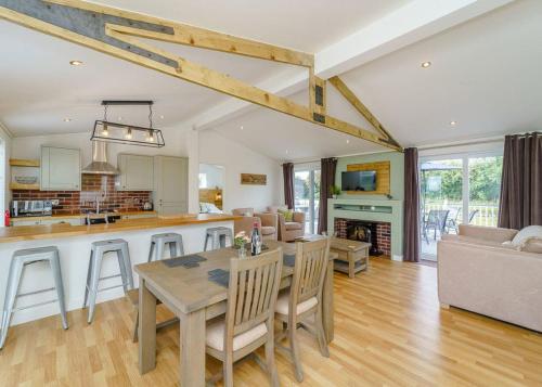 a kitchen and living room with a table and chairs at Winston Farm Lodges 