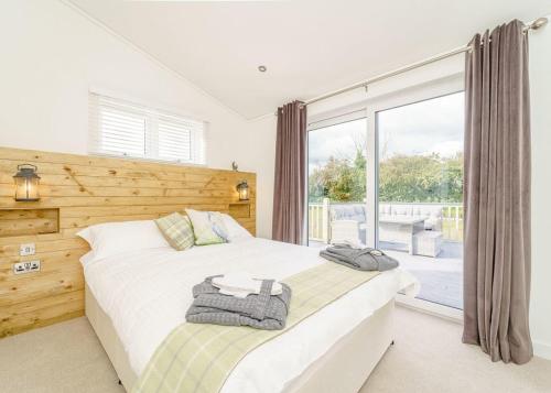 a bedroom with two beds and a large window at Winston Farm Lodges 