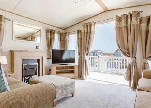 a living room with a television and a fireplace at Looe Coastal Retreat in Looe