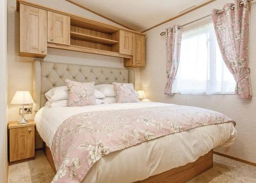 a bedroom with a large bed and a window at Looe Coastal Retreat in Looe