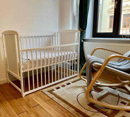 a baby crib in a room with a window at Chira Chiralina Classic Apartment in Brăila