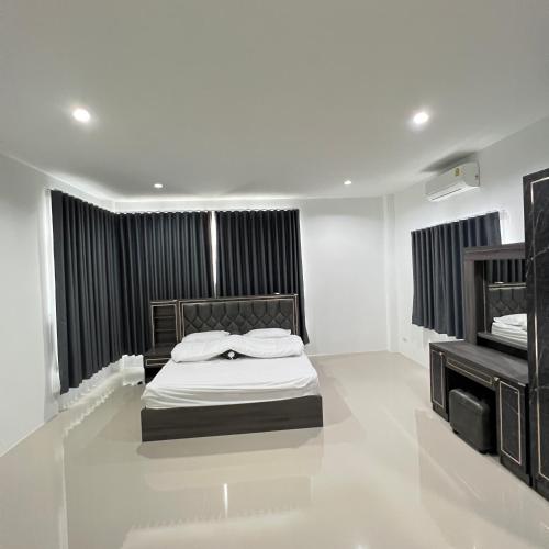 una camera bianca con letto e televisore di บ้านเดี่ยว 4 ห้องนอน 3 ห้องน้ำ a Ban Noi Pho Kham