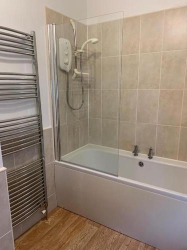 een badkamer met een douche en een bad bij Central 3 Bedroom Townhouse in Wick