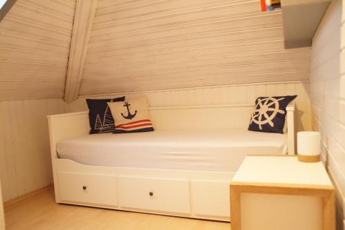 ein kleines Zimmer mit einem Bett mit Kissen darauf in der Unterkunft Ferienwohnung Robbe in Cuxhaven