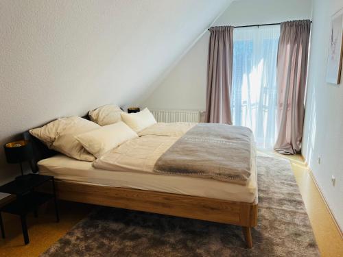 a bed in a room with a large window at FeWo 2 an der historischen Bahnlinie in Leutkirch im Allgäu