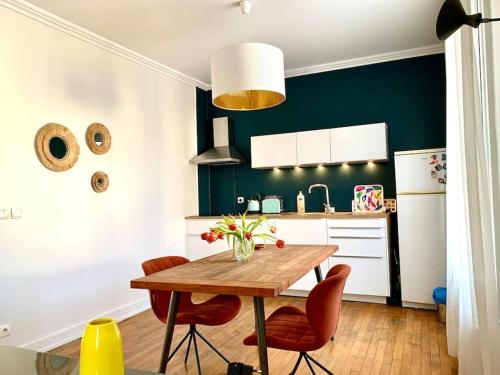 een keuken met een houten tafel en rode stoelen bij appartement moderne et lumineux in Clamart