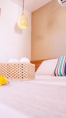 a bedroom with a white bed and a chandelier at Chalés Mahalo J - Pontal de Maceió - Fortim in Fortim