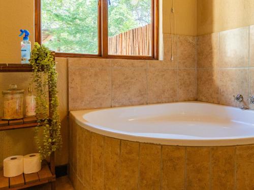a bath tub in a bathroom with a window at Impala Cottage in Hoedspruit