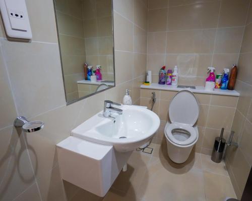 ドーハにあるLuxury Apartment by the Sea with Amazing Amenities at Pearl Qatarの洗面台、トイレ、鏡のあるバスルーム