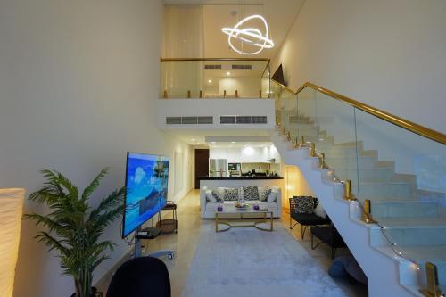 a living room with a staircase with a couch at Luxury Apartment by the Sea with Amazing Amenities at Pearl Qatar in Doha