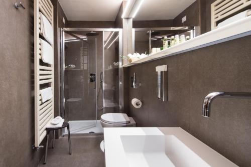 a bathroom with a tub and a toilet and a sink at Hotel La Cisterna in San Gimignano