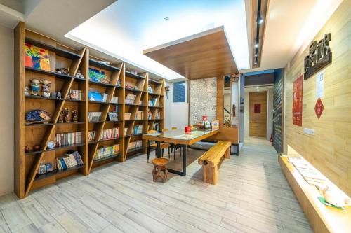a library with wooden shelves and a wooden table and bench at Enjoy Homestay in Tainan