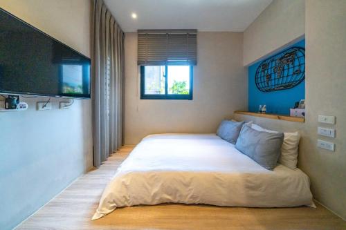 a bedroom with a large bed and a flat screen tv at Enjoy Homestay in Tainan