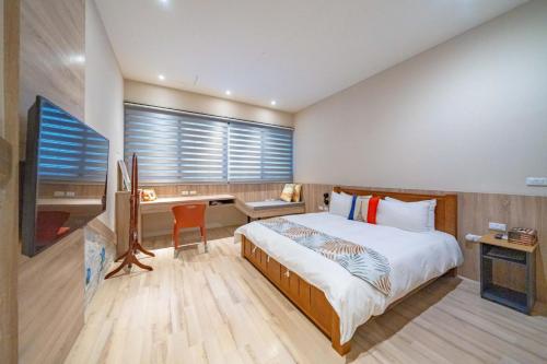 a bedroom with a bed and a desk and a window at Enjoy Homestay in Tainan