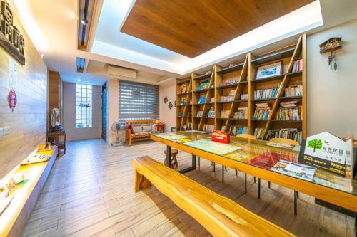 a room with a library with a table and bookshelves at Enjoy Homestay in Tainan