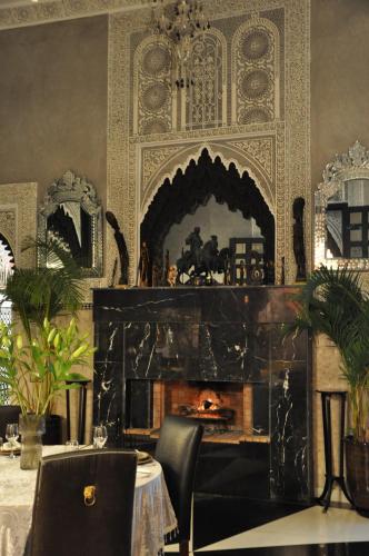 a fireplace in a dining room with a table and chairs at Dar Chrifa in Rabat