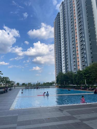 uma piscina com pessoas em frente a um edifício em Santai at KotaWarisan KLIA Netflix em Sepang