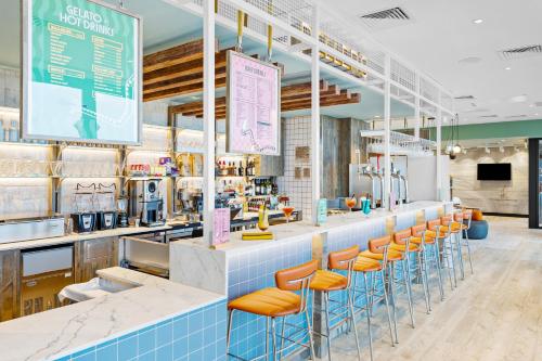 a restaurant with orange stools at a counter at ibis Styles Paignton in Paignton