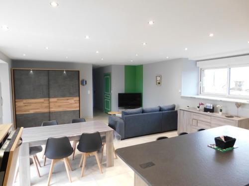 a living room with a couch and a table and chairs at gite de la laiserie in Mesnil-Clinchamps