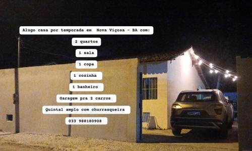 une voiture garée à côté d'un bâtiment avec des panneaux indiquant la rue dans l'établissement CASA DE PRAIA DO MINEIRO - A 300 metros do MAR, à Nova Viçosa