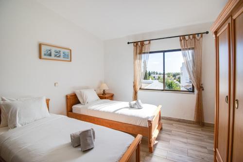 twee bedden in een kamer met een raam bij Renovated Oasis 500m Beach AC Wi-Fi Pool Balcony in Albufeira